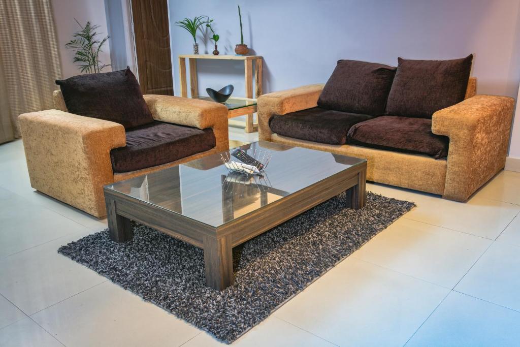 uma sala de estar com dois sofás e uma mesa de centro em The Pines Serviced Apartments em Patan