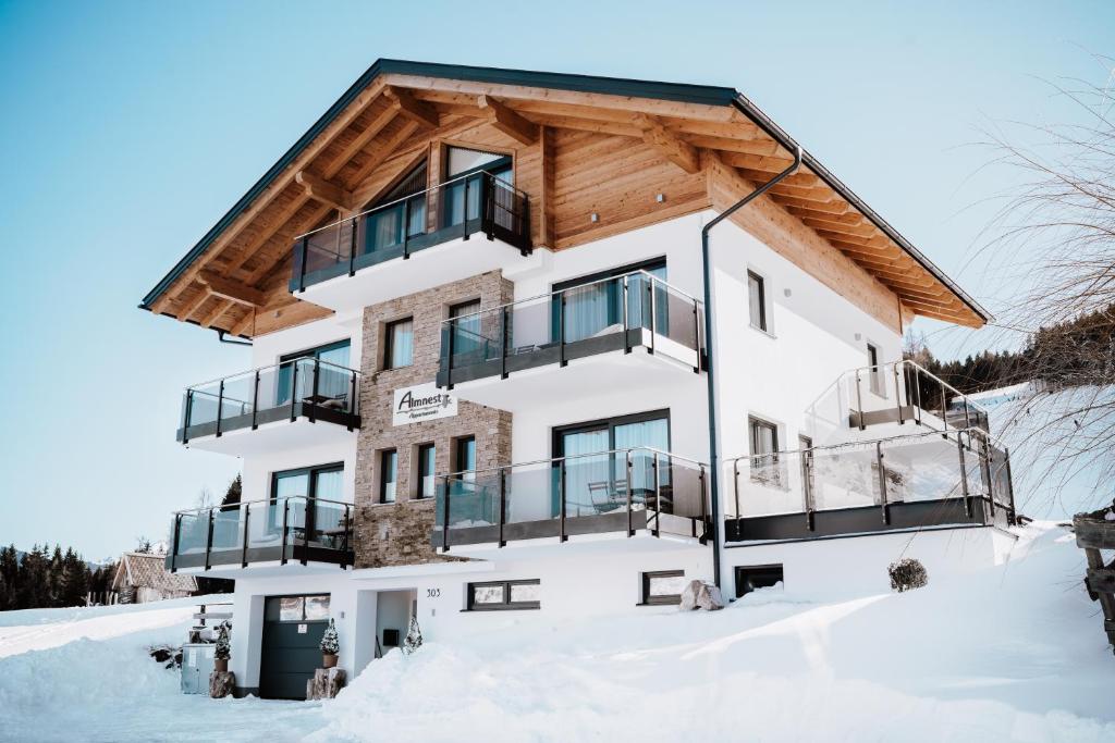 a house in the snow with a wooden roof at Appartements Almnest in Schladming