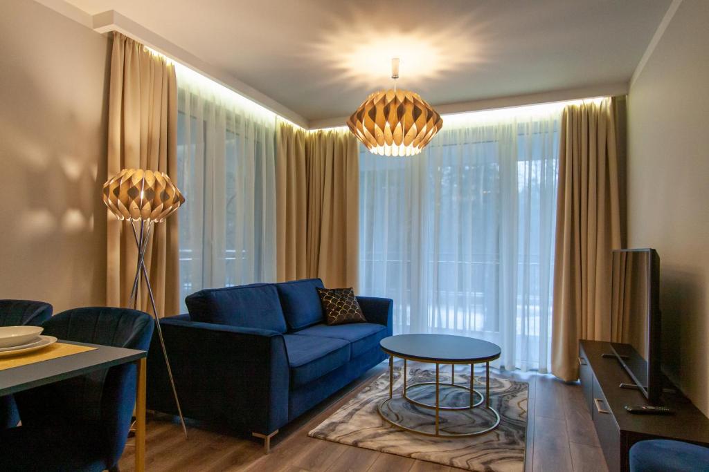 salon z niebieską kanapą i stołem w obiekcie Apartament Leśny No 4 Blue w Kielcach