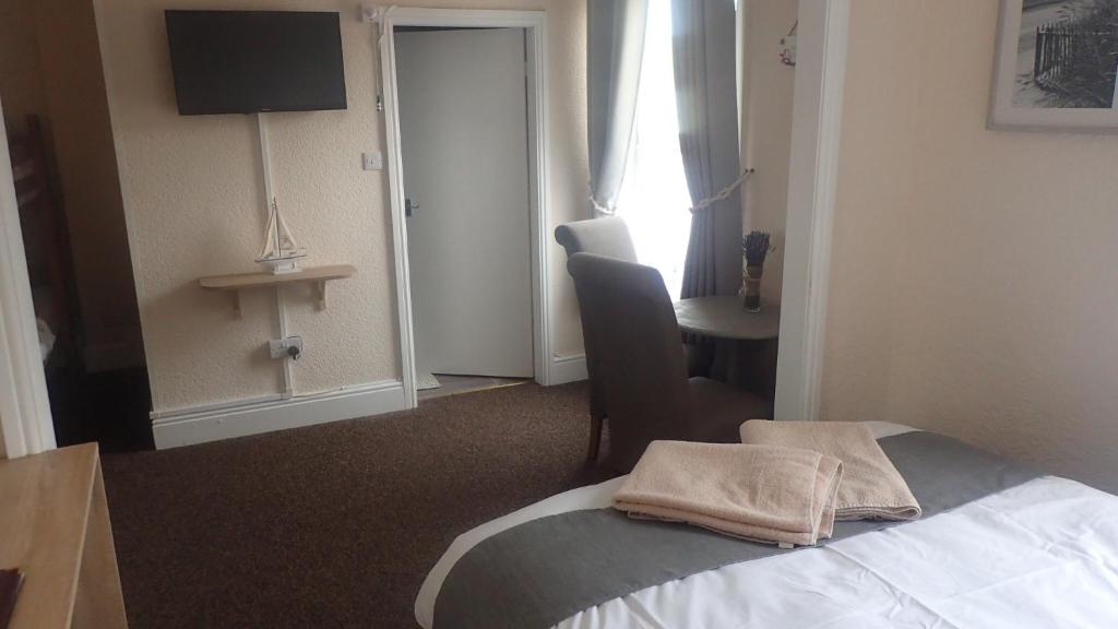 a hotel room with a bed and a chair and a desk at The Victoria guest house in Mablethorpe