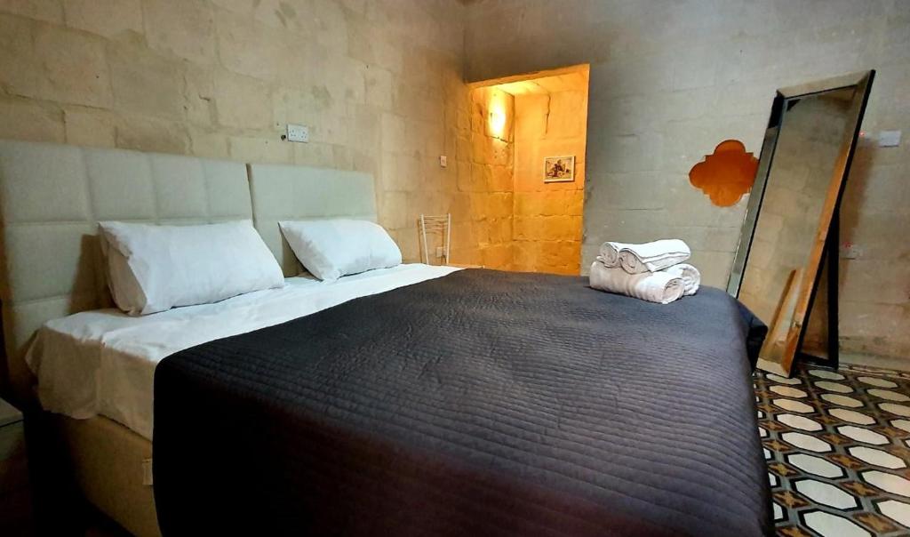 a bedroom with a large bed with two towels on it at Valletta Lucia Townhouse in Valletta
