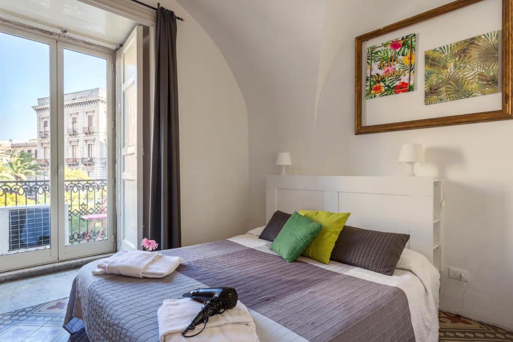 a bedroom with a bed and a large window at Da Gianni e Lucia Rooms with bathroom in the city center in Catania