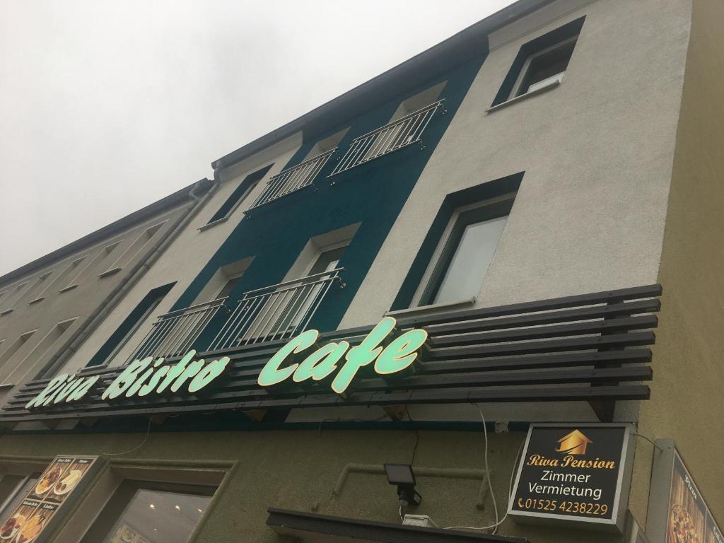 a building with a sign that reads the dining cafe at Riva Pension in Taucha