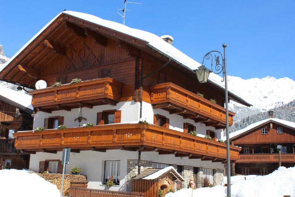 a large wooden building with snow on the roof at B&B Daina Hame in Sappada