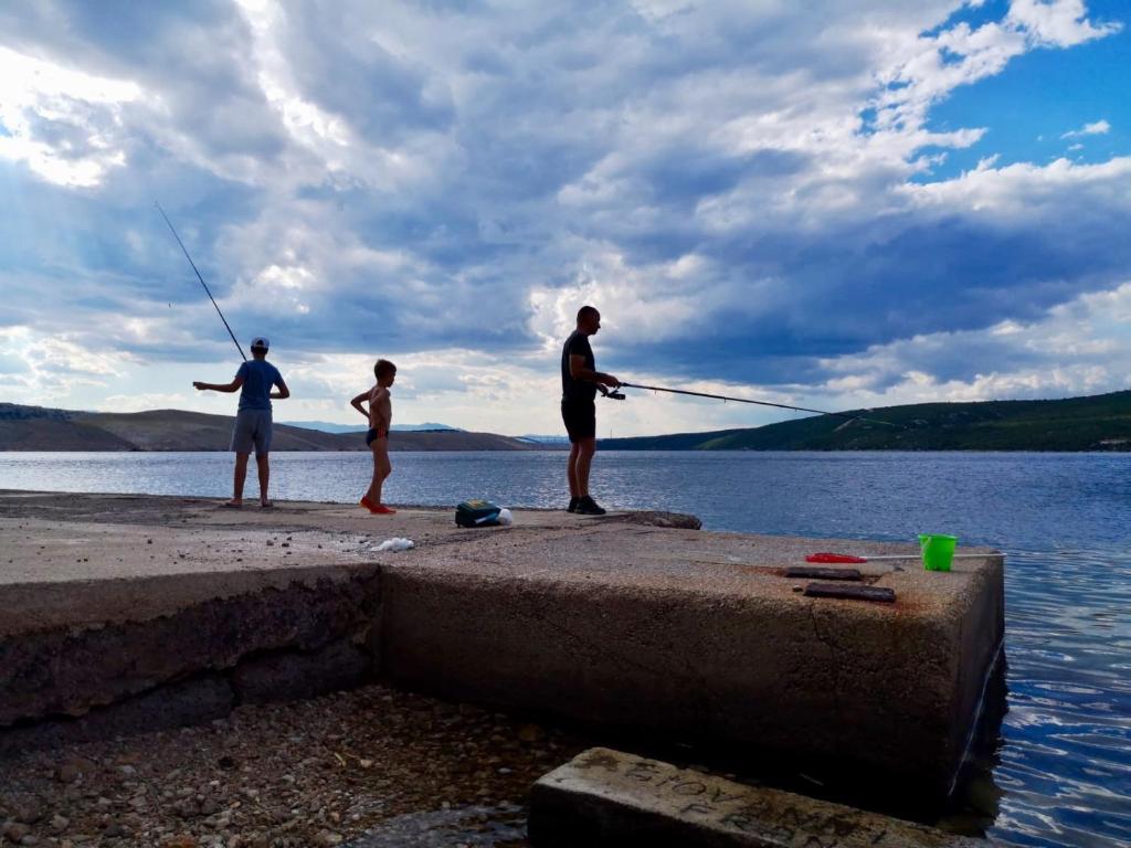 een groep van drie mensen die op een pier vissen bij amz AP2 in Jadranovo