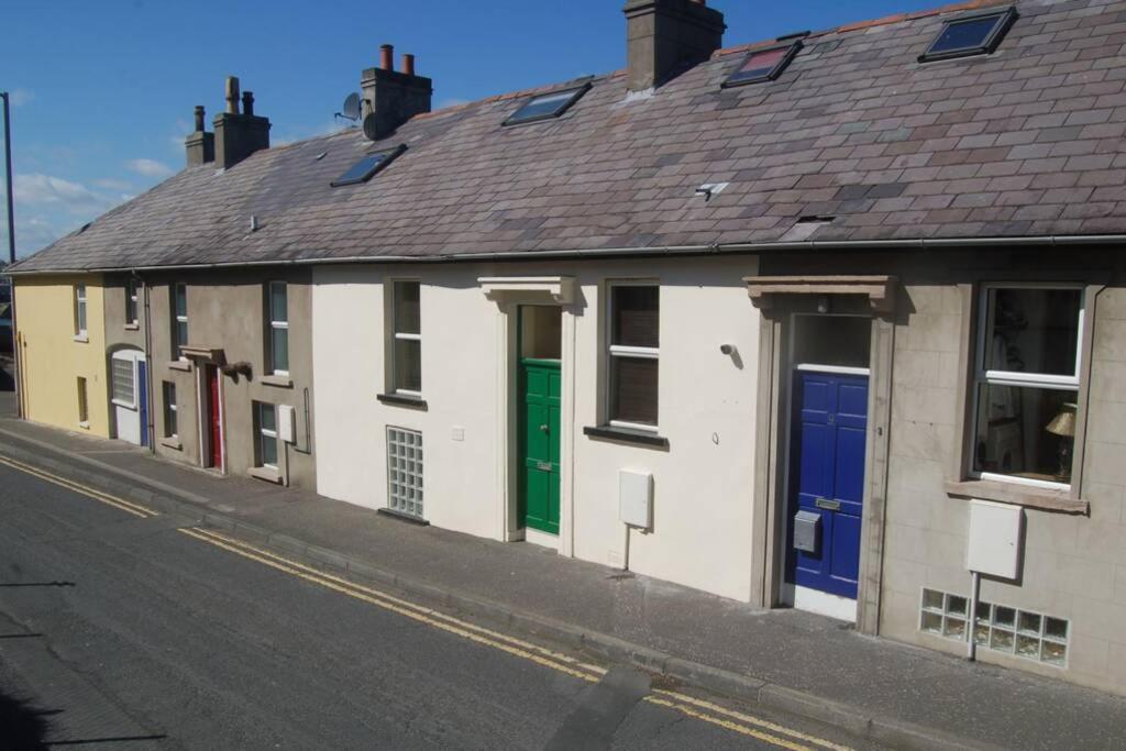 een rij huizen met kleurrijke deuren in een straat bij Splash Cottage, Bangor, Co Down in Bangor