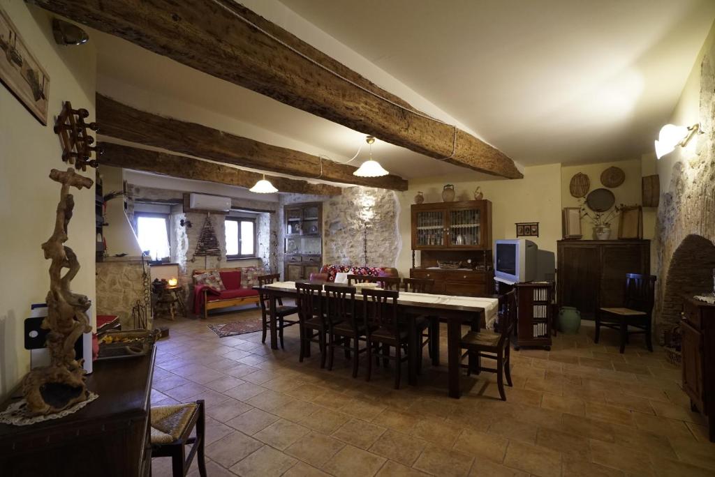 a dining room and living room with a table and chairs at LA RICCIOLINA B&B in Palombaro