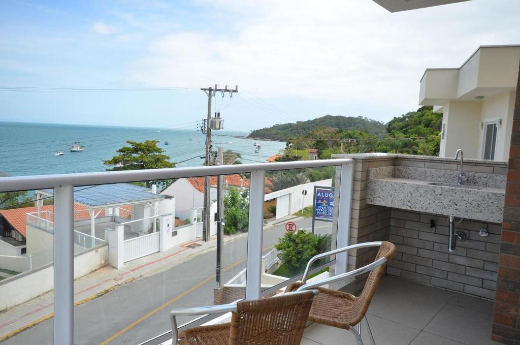 balcón con 2 sillas y vistas al océano en 1078 - Apartamento com vista para o mar em Bombinhas, en Bombinhas
