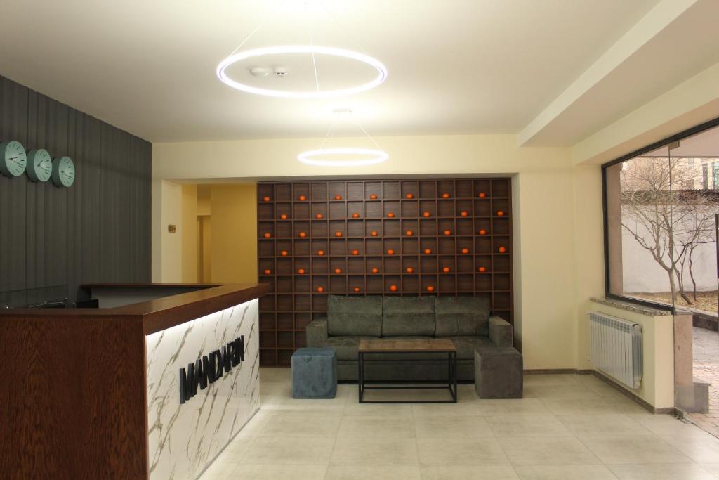 a lobby with a couch and a wall of wine bottles at MANDARIN Hotel in Yerevan