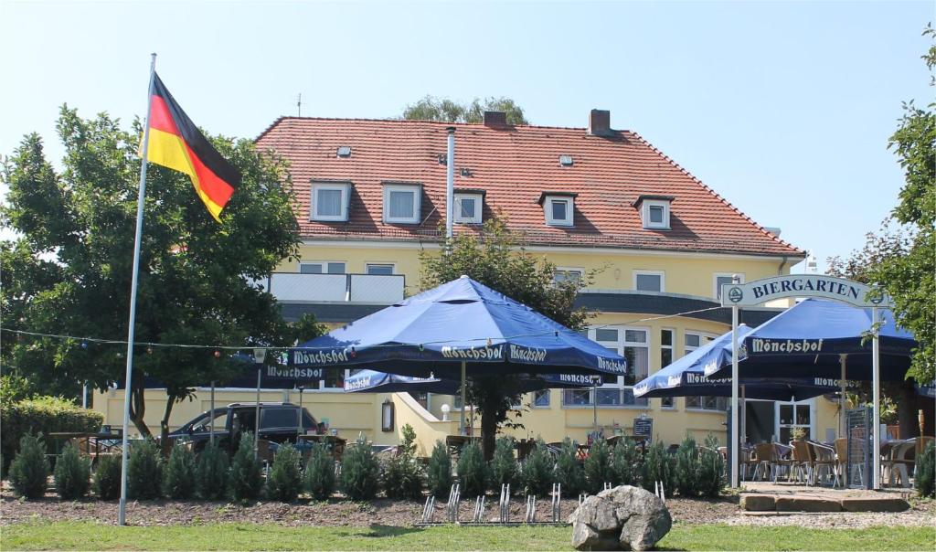 uma bandeira e guarda-chuvas em frente a um edifício em Gasthaus Neue Mühle em Kassel
