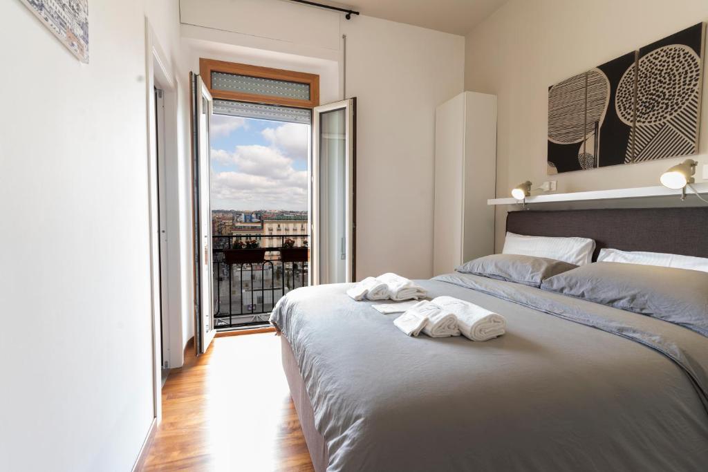ein Schlafzimmer mit einem Bett und einem großen Fenster in der Unterkunft Florestine Napoli in Neapel