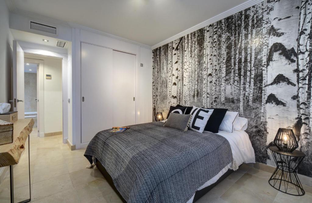 ein Schlafzimmer mit einem Bett und einem Wandbild in der Unterkunft Boho Style Flat- Acosta in Estepona
