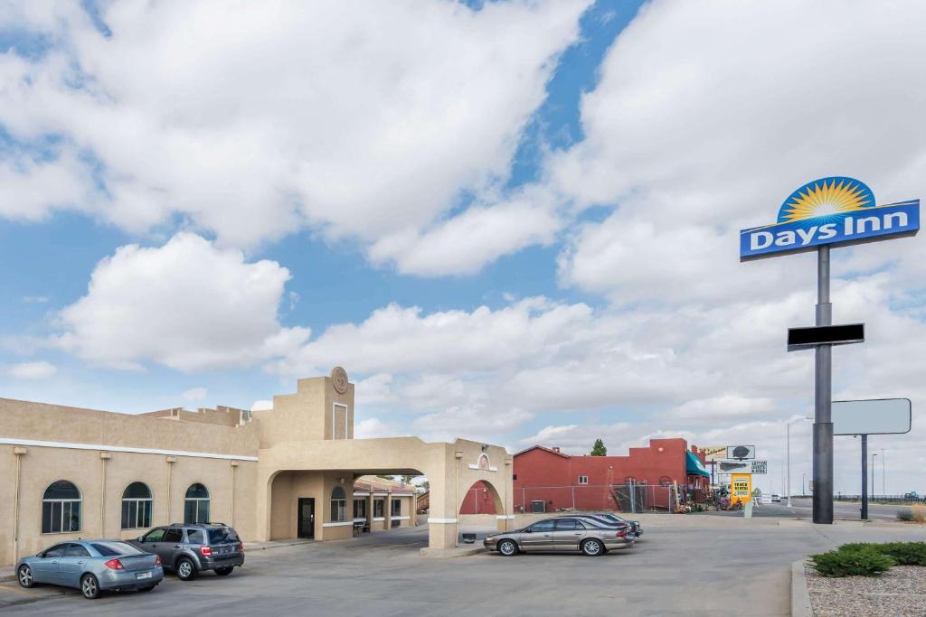 un letrero de la calle con coches aparcados en un estacionamiento en Days Inn by Wyndham Pueblo, en Pueblo