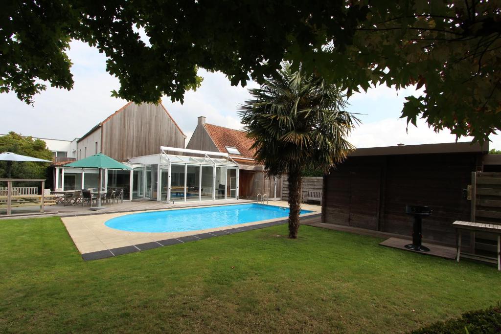 une maison avec une piscine dans une cour dans l'établissement NUVOLA VILLA, à Zottegem