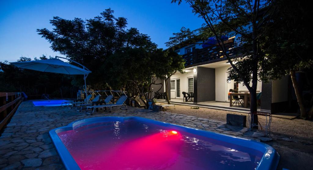 a bath tub with a red light in front of a house at Apartmani Mabele in Pag