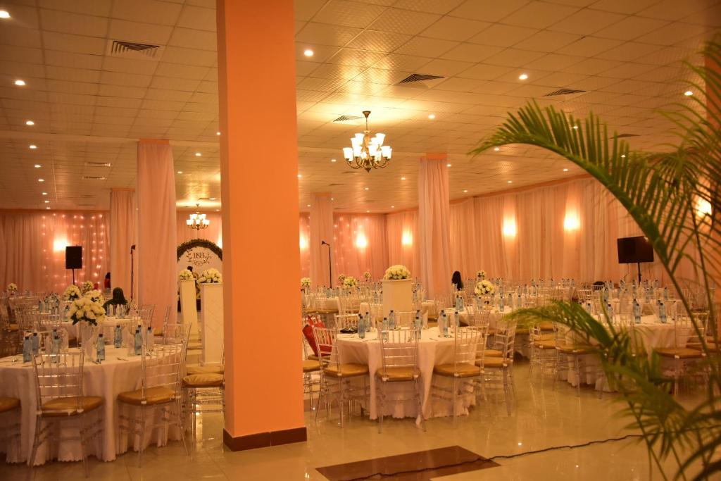 a banquet hall with white tables and chairs at Hotel Blue Sapphire in Dar es Salaam