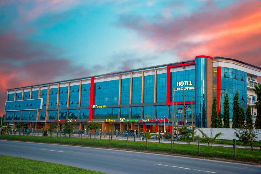 a large glass building with a red and blue facade at Hotel Blue Sapphire in Dar es Salaam