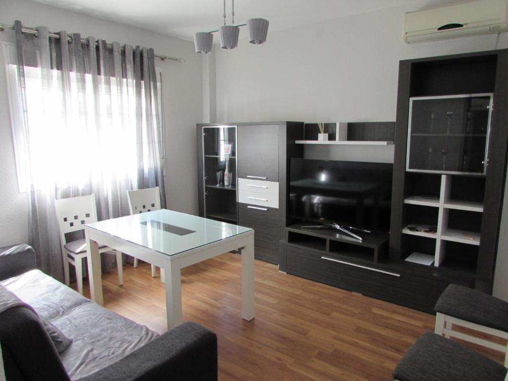 a living room with a white table and a black cabinet at Luz y Mar in Aljaraque