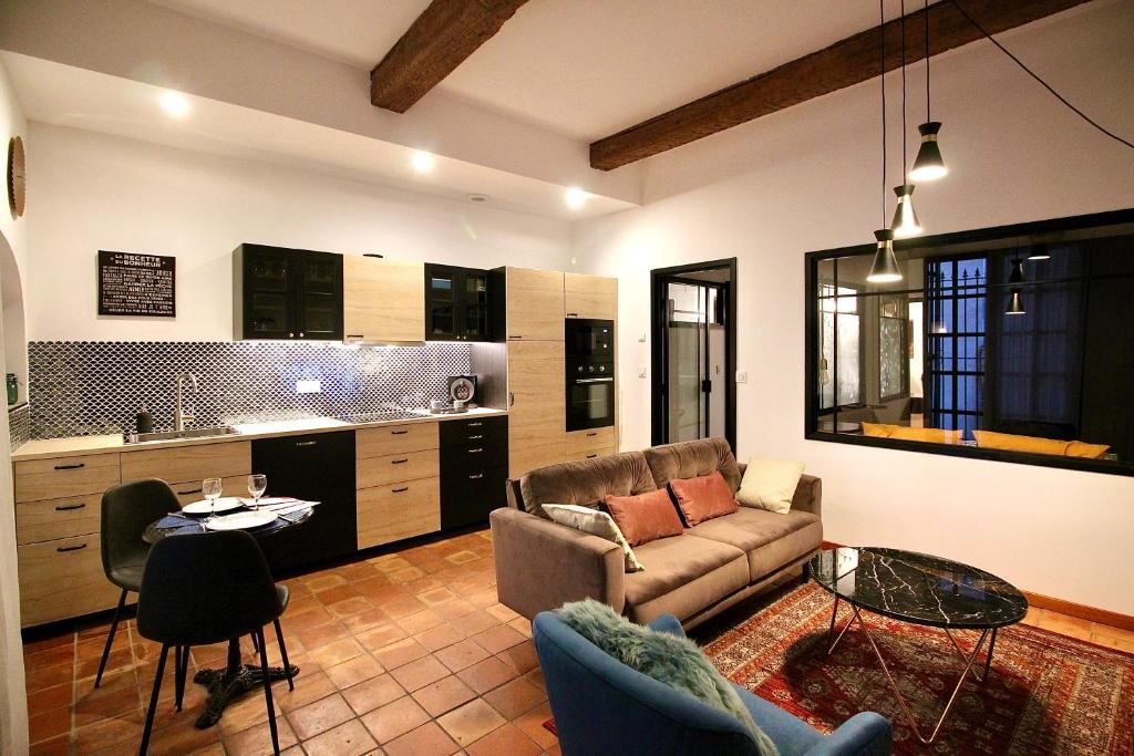 a living room with a couch and a table at Pézenas Cocoon in Pézenas