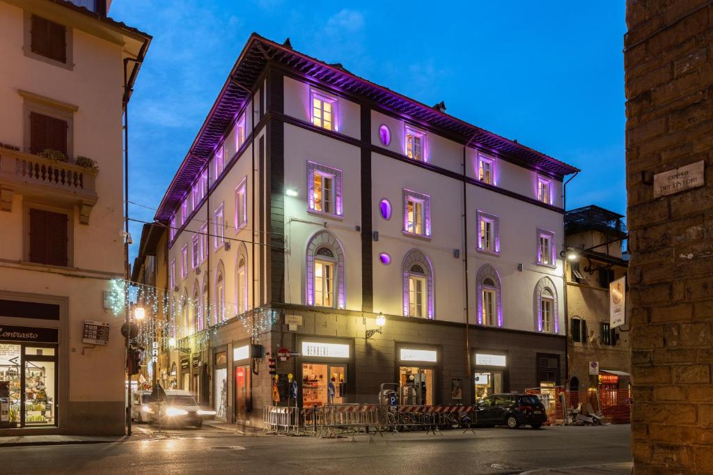 a building with purple lights on it on a street at Kairos by Florence Art Apartments in Florence