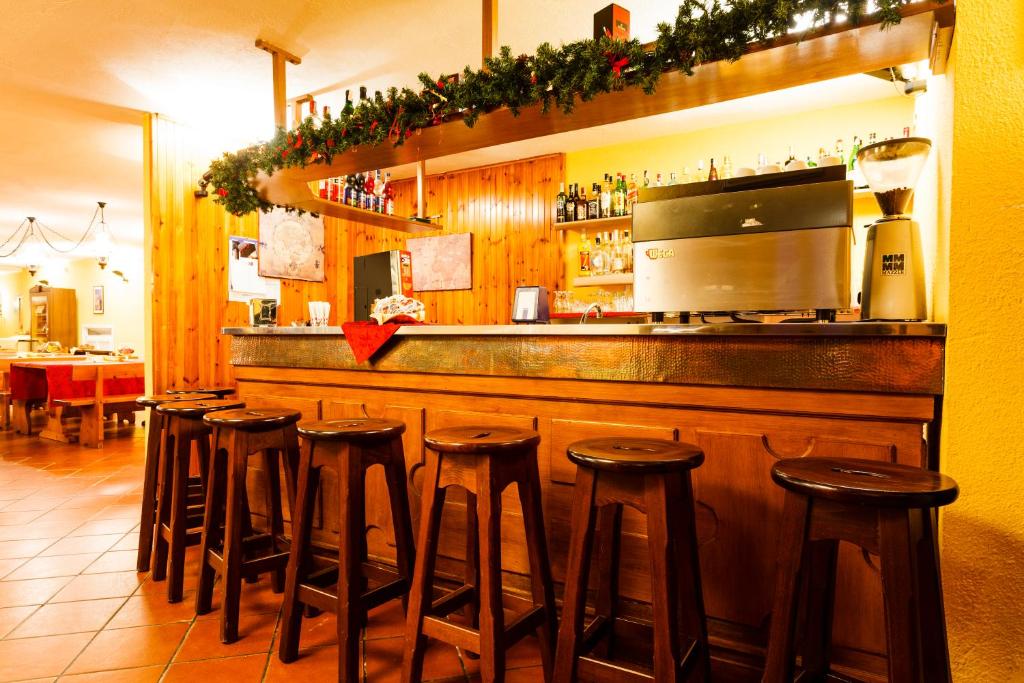 a bar with a row of stools in a restaurant at Hotel Biancaneve in Sestriere