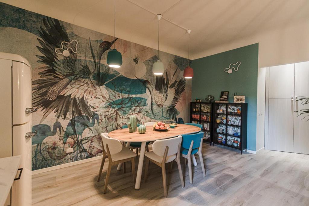 a kitchen with a table with chairs and a mural at ROOMS LibertyHouse Firenze in Florence
