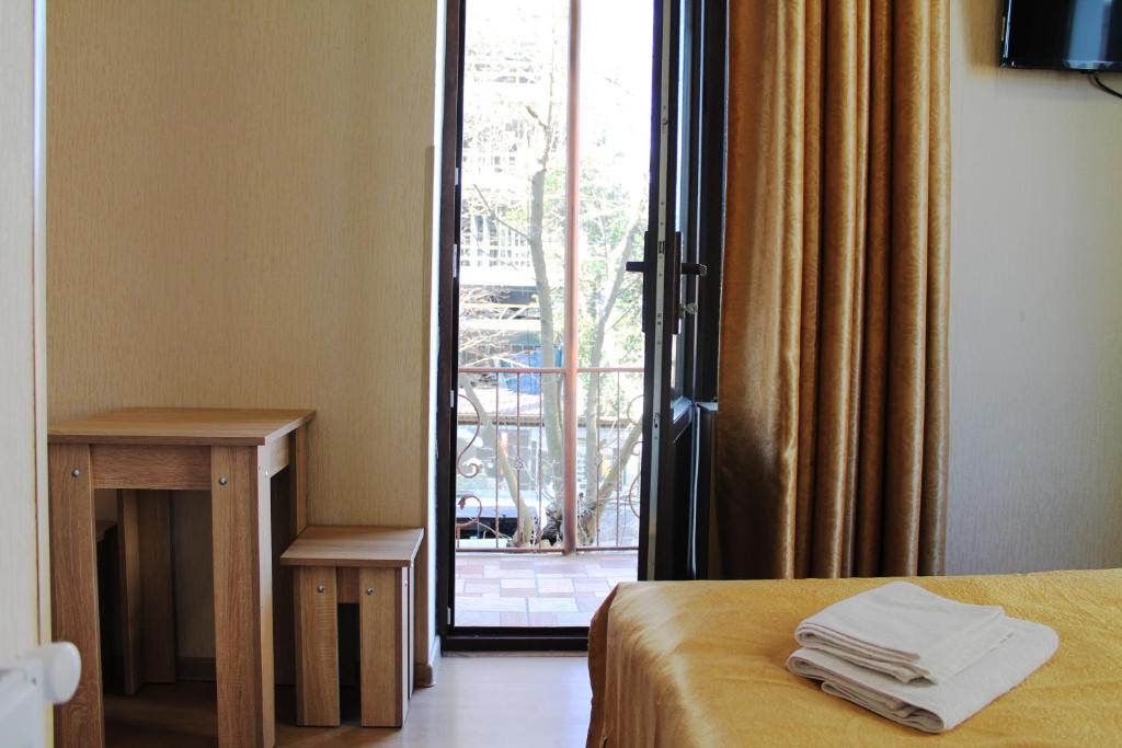 a room with a bed and a sliding glass door at Hotel White Bridge in Kutaisi