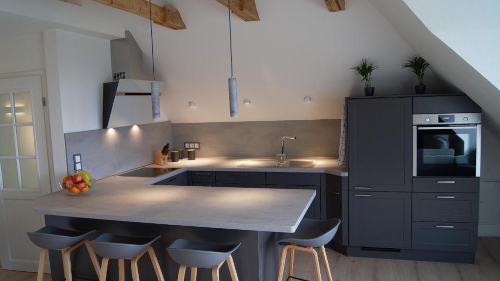 a kitchen with a sink and a counter with stools at Ferienwohnung Lohf in Handewitt