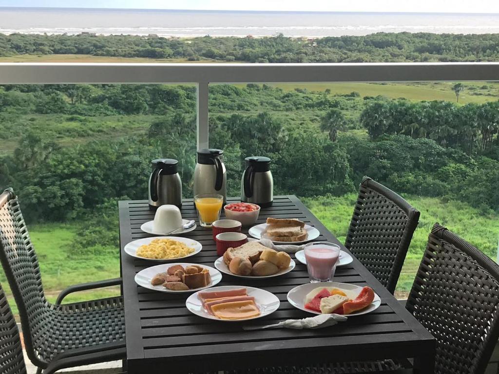 a table with breakfast foods on it on a balcony at SALINAS PARK RESORT - Melhor Resort do Norte in Salinópolis