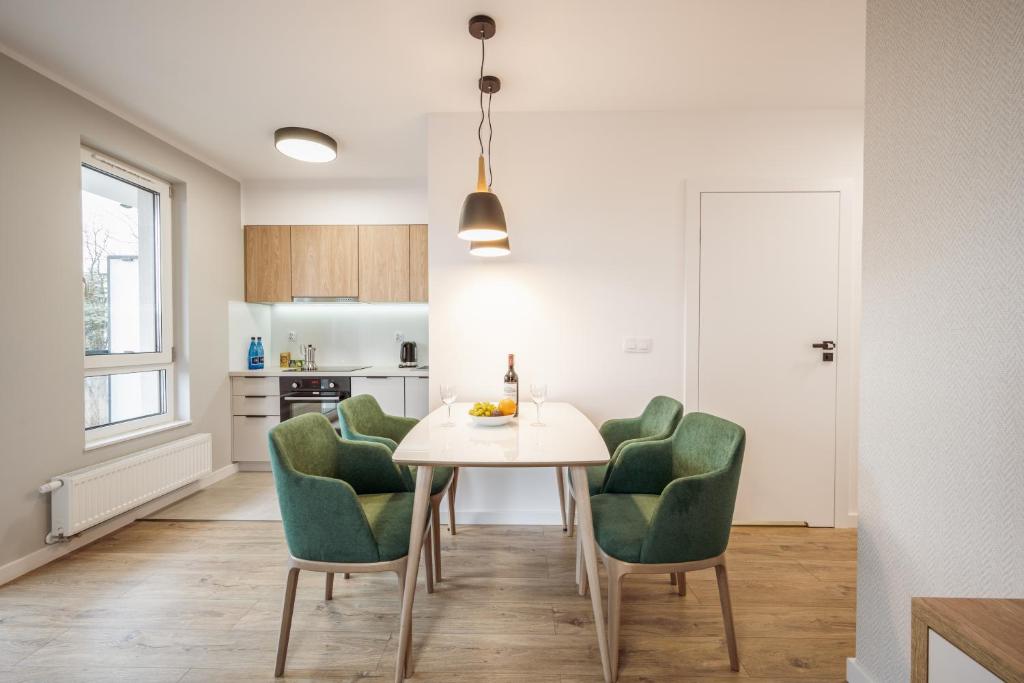 a kitchen and dining room with a table and chairs at Marina Apartments in Wrocław