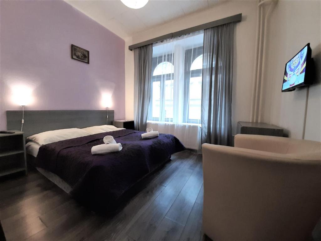 sypialnia z łóżkiem i dwoma ręcznikami na nim w obiekcie Hotel Olga w Pradze