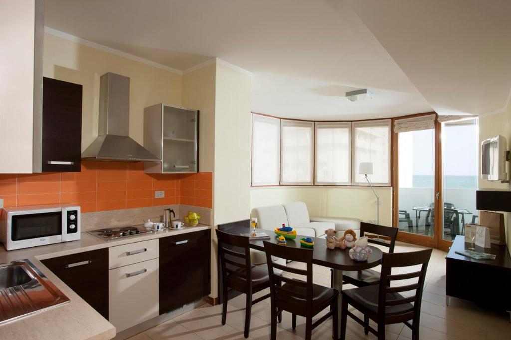 a kitchen with a table and chairs in a kitchen at Il Teatro in Lido di Jesolo
