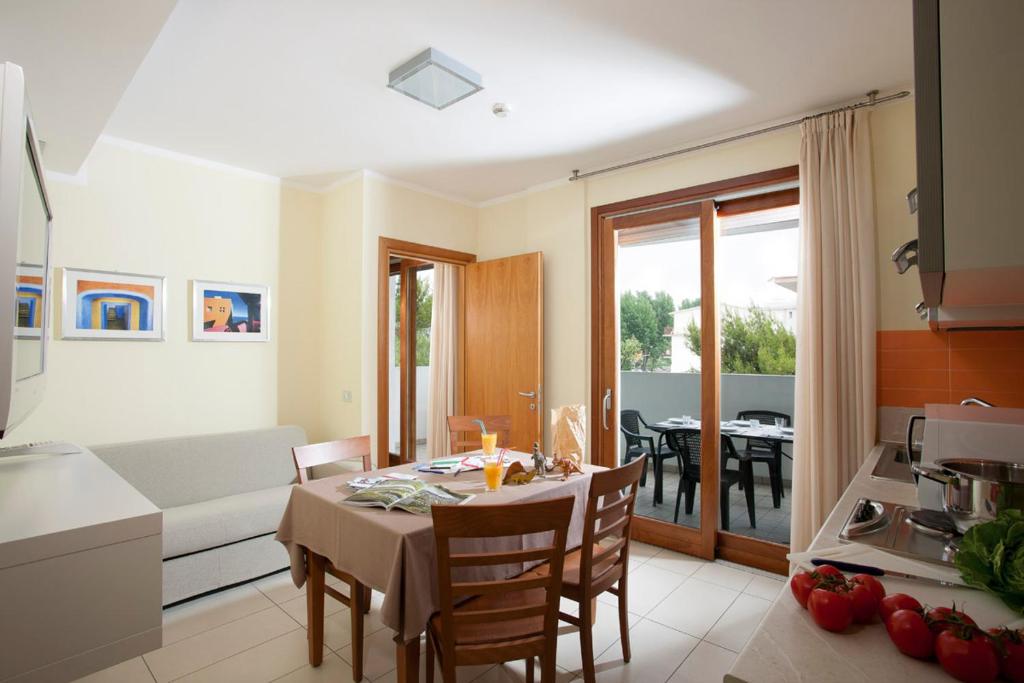 a kitchen and living room with a table and chairs at Il Teatro in Lido di Jesolo