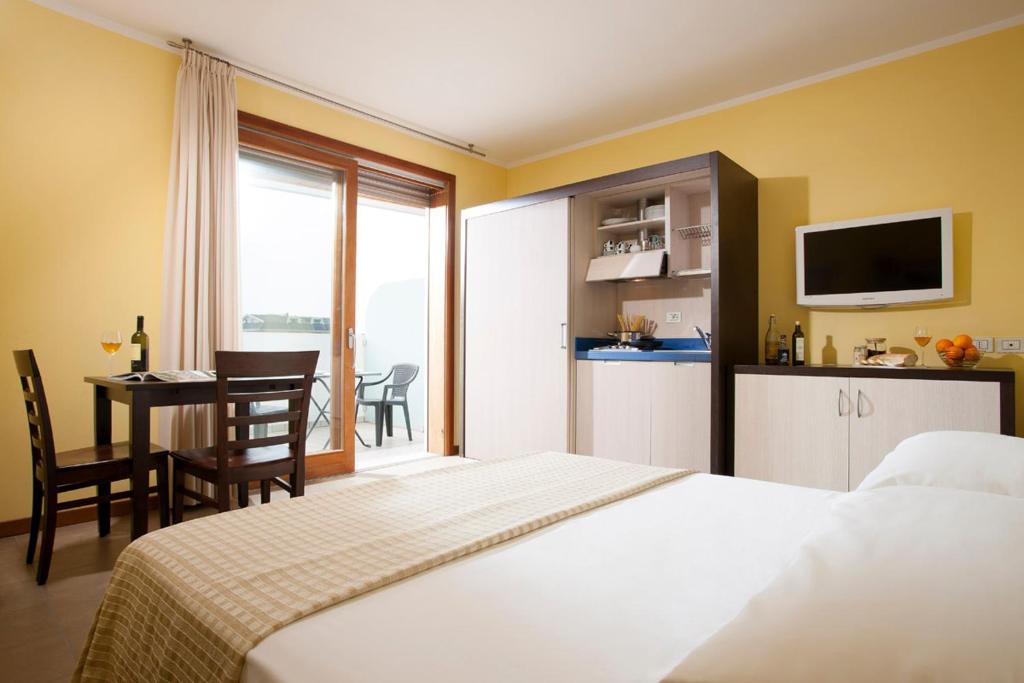 a hotel room with a bed and a table and a kitchen at Il Teatro in Lido di Jesolo