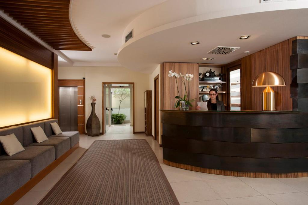 a lobby of a hotel with a woman standing at a counter at Il Teatro in Lido di Jesolo