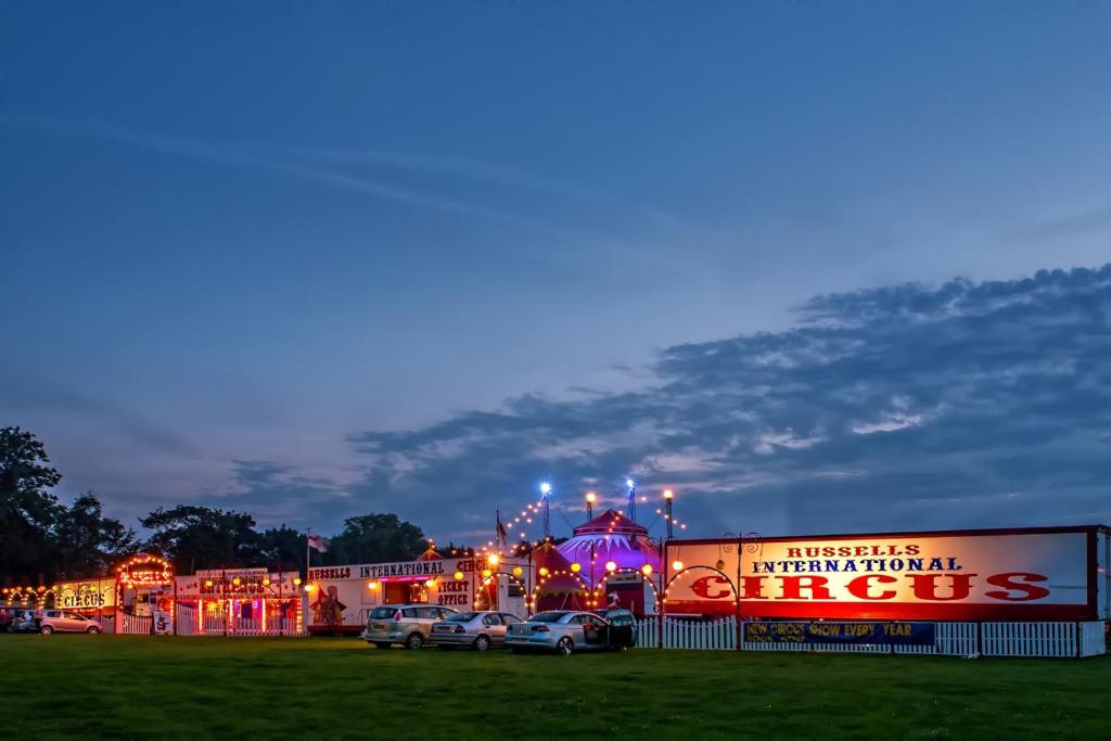 a building with cars parked in a parking lot at night at Vintage, Circus Holiday Home in Mablethorpe