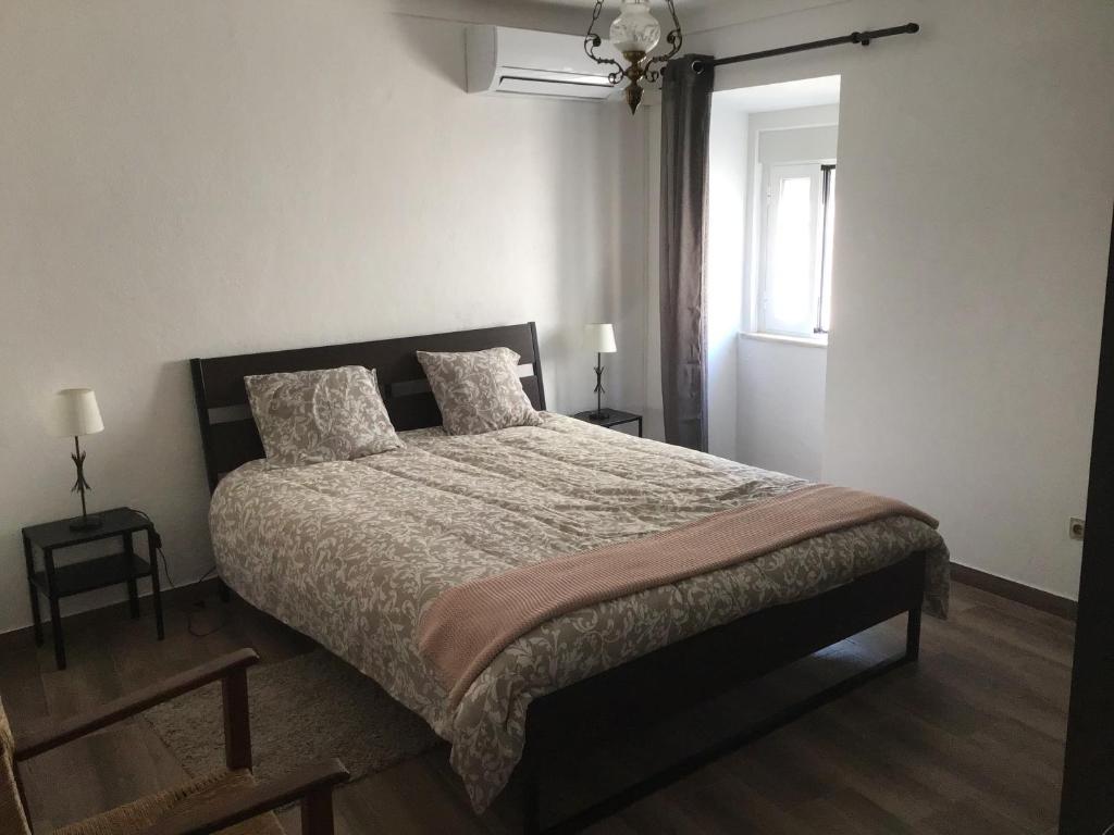 sypialnia z łóżkiem i oknem w obiekcie Casa Cardinho - A sua casa no Alentejo w mieście Castelo de Vide