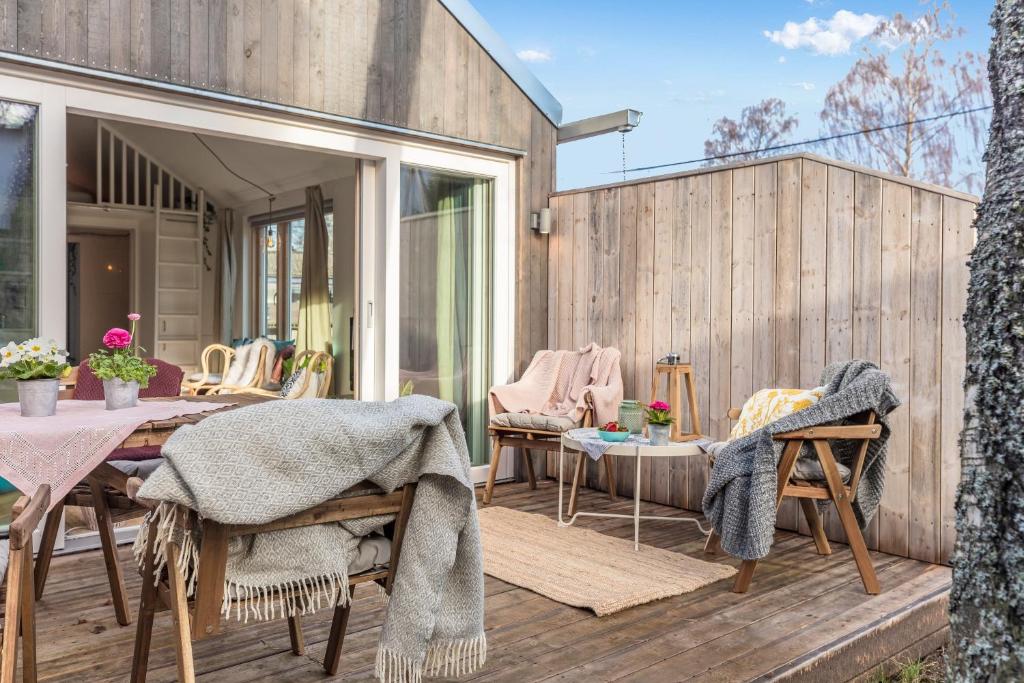 a patio with a table and chairs on a wooden deck at Sparkling newly built house close to city & nature in Stockholm