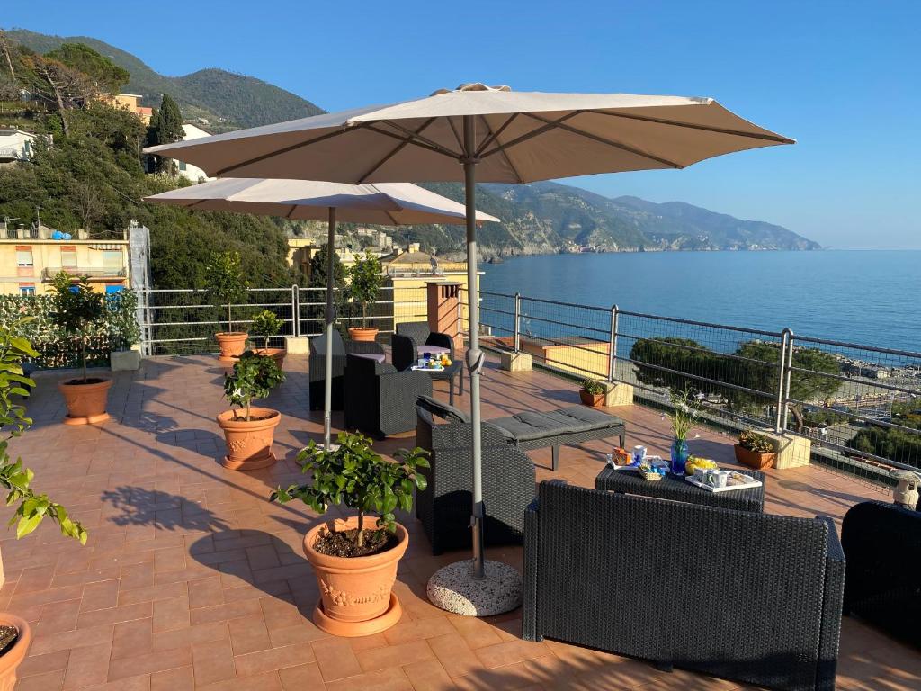 a patio with an umbrella and chairs and the ocean at L'ancora di Monterosso - Cinque Terre in Monterosso al Mare