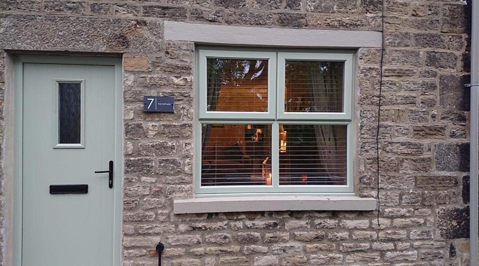 un edificio in mattoni con finestra e porta bianca di Number 7 The Cottage A Rural Retreat a Durham