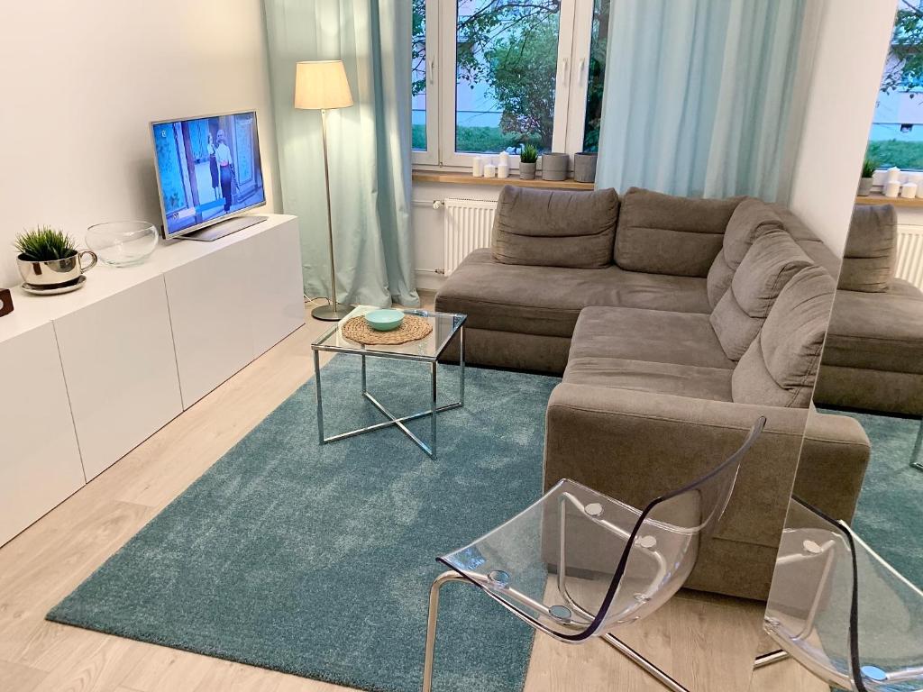 a living room with a couch and a table at Apartament Sucharskiego in Toruń