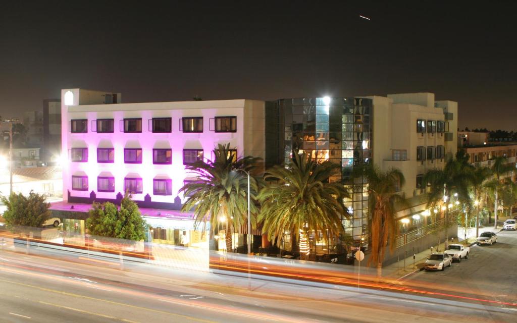 a city street at night with buildings and palm trees at Garden Suite Hotel and Resort in Los Angeles