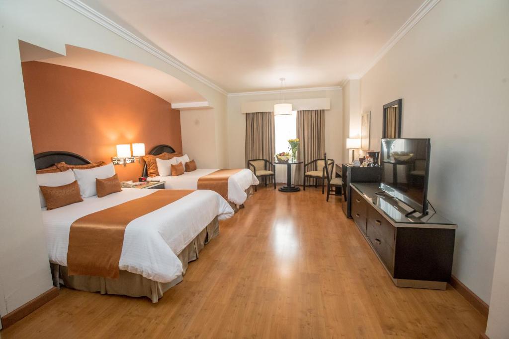 蒙特雷的住宿－德奧羅廣場酒店，酒店客房设有两张床和一台平面电视。