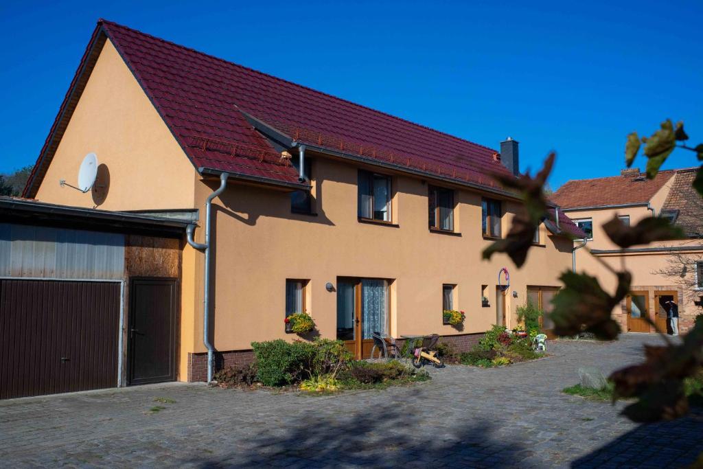ein Haus mit einem roten Dach und einer Garage in der Unterkunft Gästehaus Schulz in Schenkendöbern