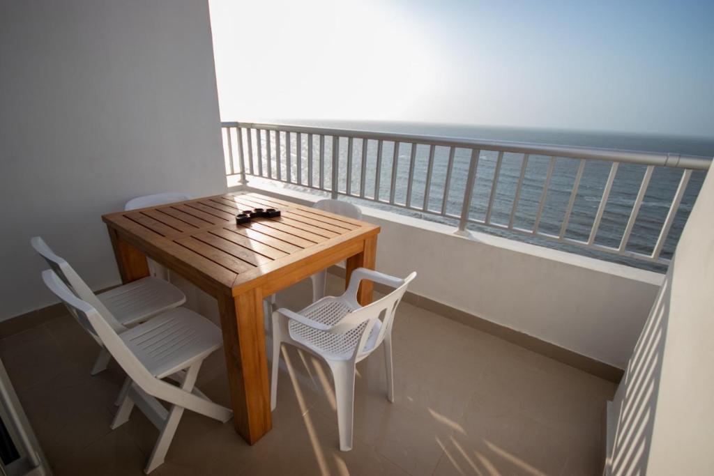 Un balcón con una mesa y dos sillas y el océano en Excelente Apartamento Palmetto con vista al mar en Cartagena de Indias