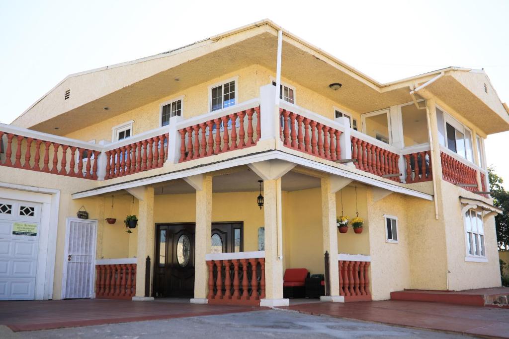 uma grande casa amarela com uma varanda em Playa Hermosa Inn at the beach em Ensenada