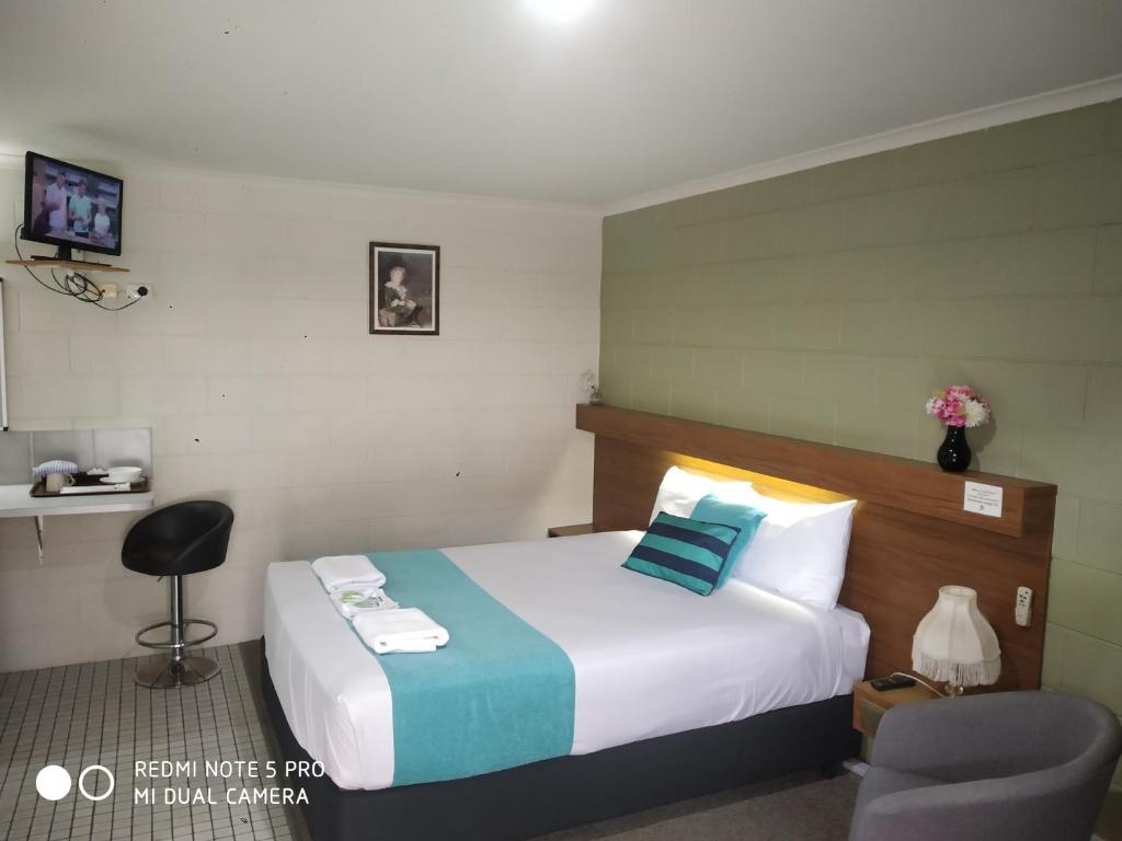 a hotel room with a bed and a desk at Albury Central Motel in Albury