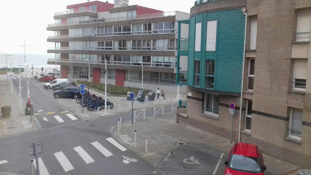 een uitzicht op een straat met auto's en gebouwen bij Passionné de la plage in Duinkerke