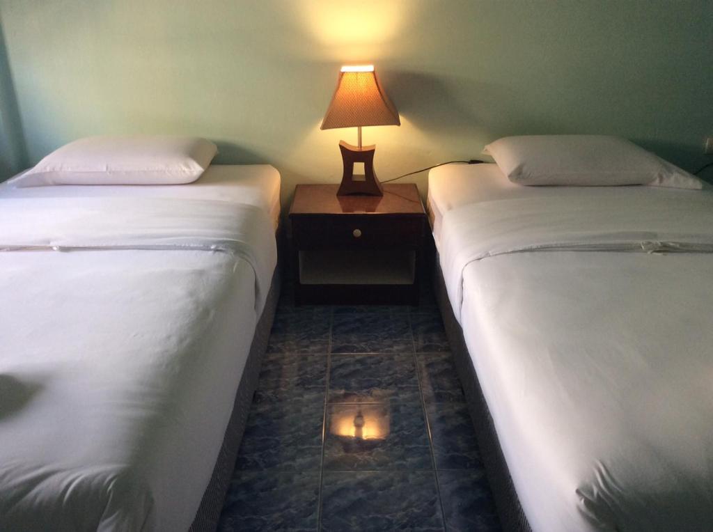 2 camas en una habitación con una lámpara en una mesa en J-2 Court en Songkhla