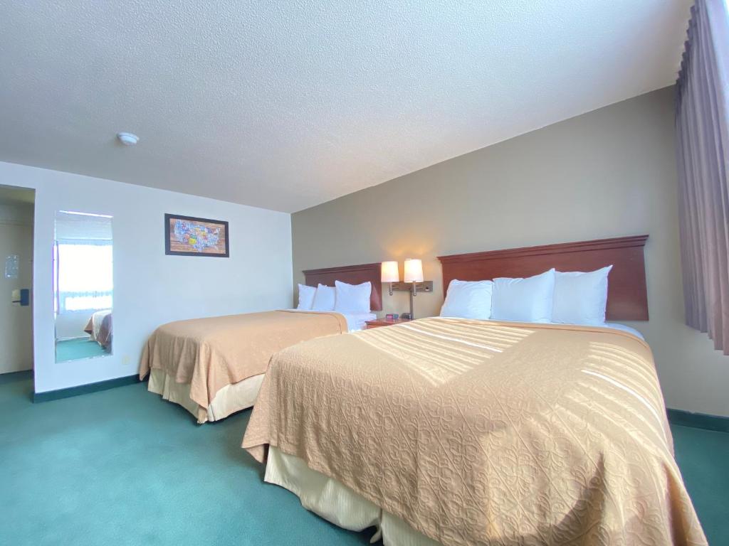 een hotelkamer met 2 bedden en een raam bij Travelodge by Wyndham Great Falls in Great Falls